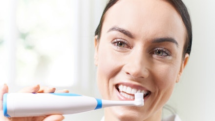 are electric toothbrushes better woman brushing teeth with electric toothbrush