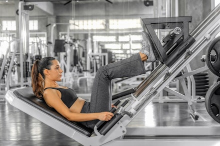 caucasian atheletic sport woman in sportswear exercising with lag press machine to build lag muscle in gym and fitness club for wellbeing lifestyle weight training for women over 50 woman on leg press