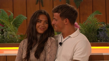 gemma-luca-love-island Gemma and Luca in the Love Island villa staring and smiling at each other while sitting at the fire pit