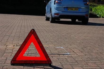 Warning triangle near a broken down car Warning triangle near a broken down car