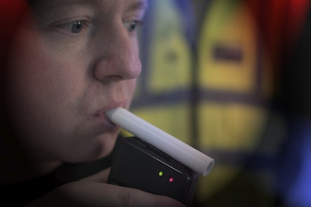 Man blowing into breathalyser Man blowing into breathalyser