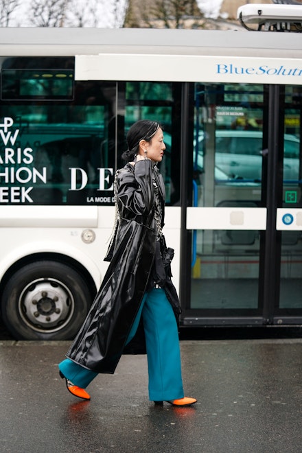 A street-styler wearing a black rain coat in Paris A street-styler wearing a black rain coat in Paris