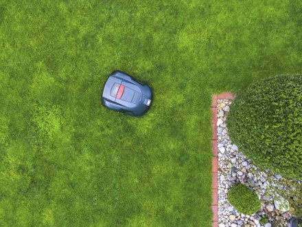 a bird's eye view of a robot lawnmower cutting grass a bird's eye view of a robot lawnmower cutting grass