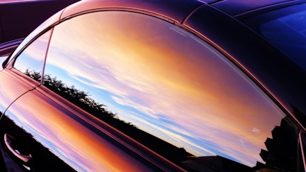 The side window of a coupe reflecting a sunset The side window of a coupe reflecting a sunset