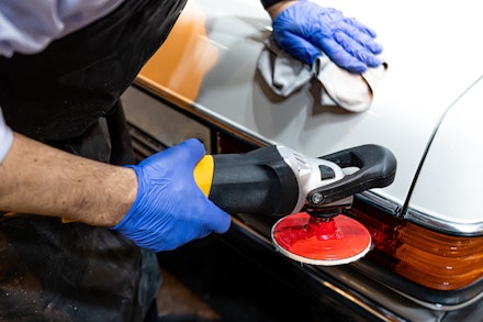 A man cleans some trim on a classic car A man cleans some trim on a classic car