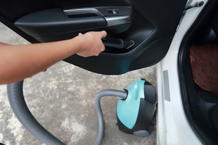 Someone vacuuming the door pocket of their car Someone vacuuming the door pocket of their car