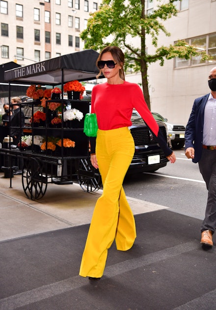 Victoria Beckham wearing flared yellow trousers Victoria Beckham wearing flared yellow trousers