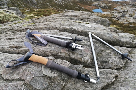 Folded trekking poles lying on a rock Folded trekking poles lying on a rock