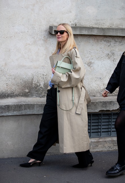 A woman wearing a trench coat at MFW A woman wearing a trench coat at MFW