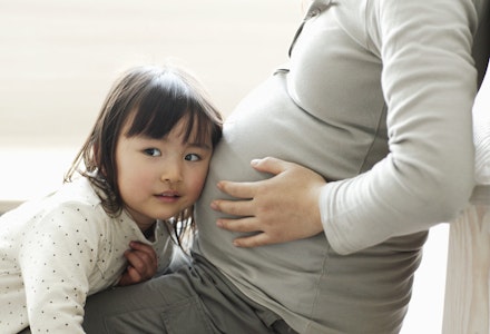 Little girl listening to pregnant mother's abdomen whats my baby doing at 28 weeks