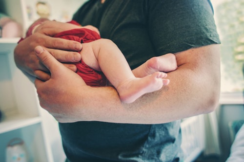Father holding his newborn baby girl Week 6