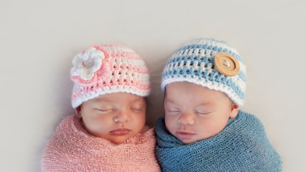a baby wearing pink and a baby wearing blue