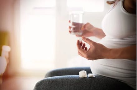 1) Heartburn and indigestion A woman holding a cup of water