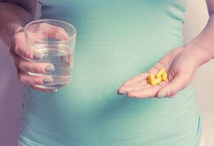 1) Start taking folic acid A woman holding vitamin capsules
