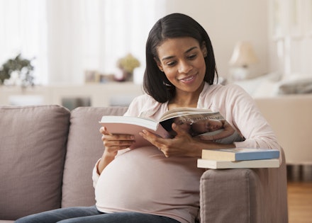 Pregnant woman sitting reading a book reading