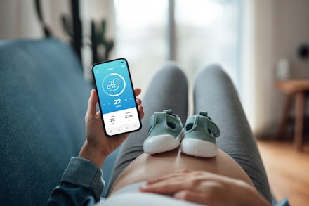 Pregnant Woman Using Telemedicine App On Smartphone Ovulation predictor test