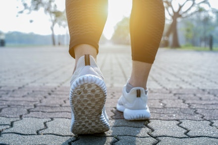 Runner feet running on road closeup on shoe. someone walking