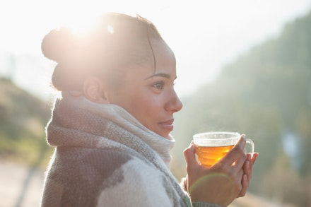 Close up of smiling woman drinking tea outdoors
