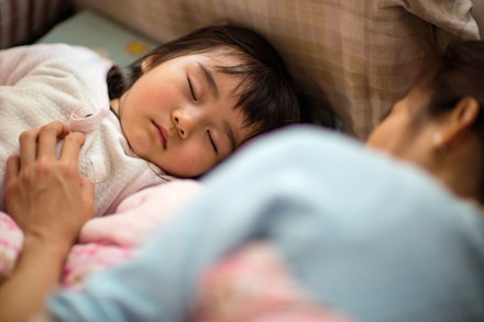 Toddler girl sleeping soundly with mom on bed toddler and parent asleep together