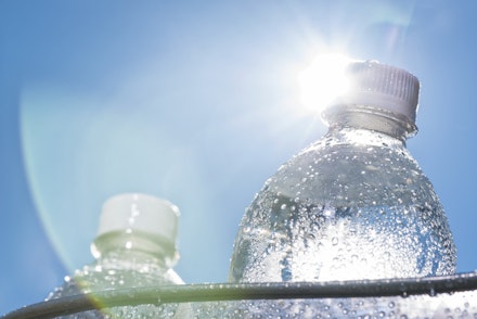 Close-up of a Ice cold water bottle in a bucket on a hot Summer day water bottle in the sun