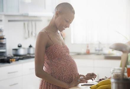 pregnant woman smiling at tablet