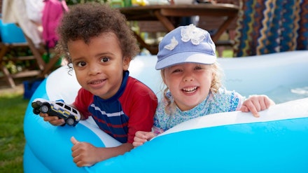 two toddlers playing in paddling pool