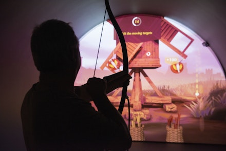 a guest taking on the long bow challenge at robin hood adventures