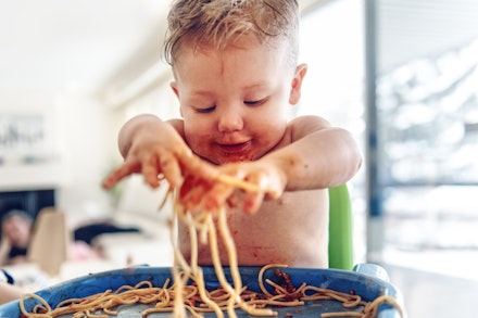 baby playing with spaghetti