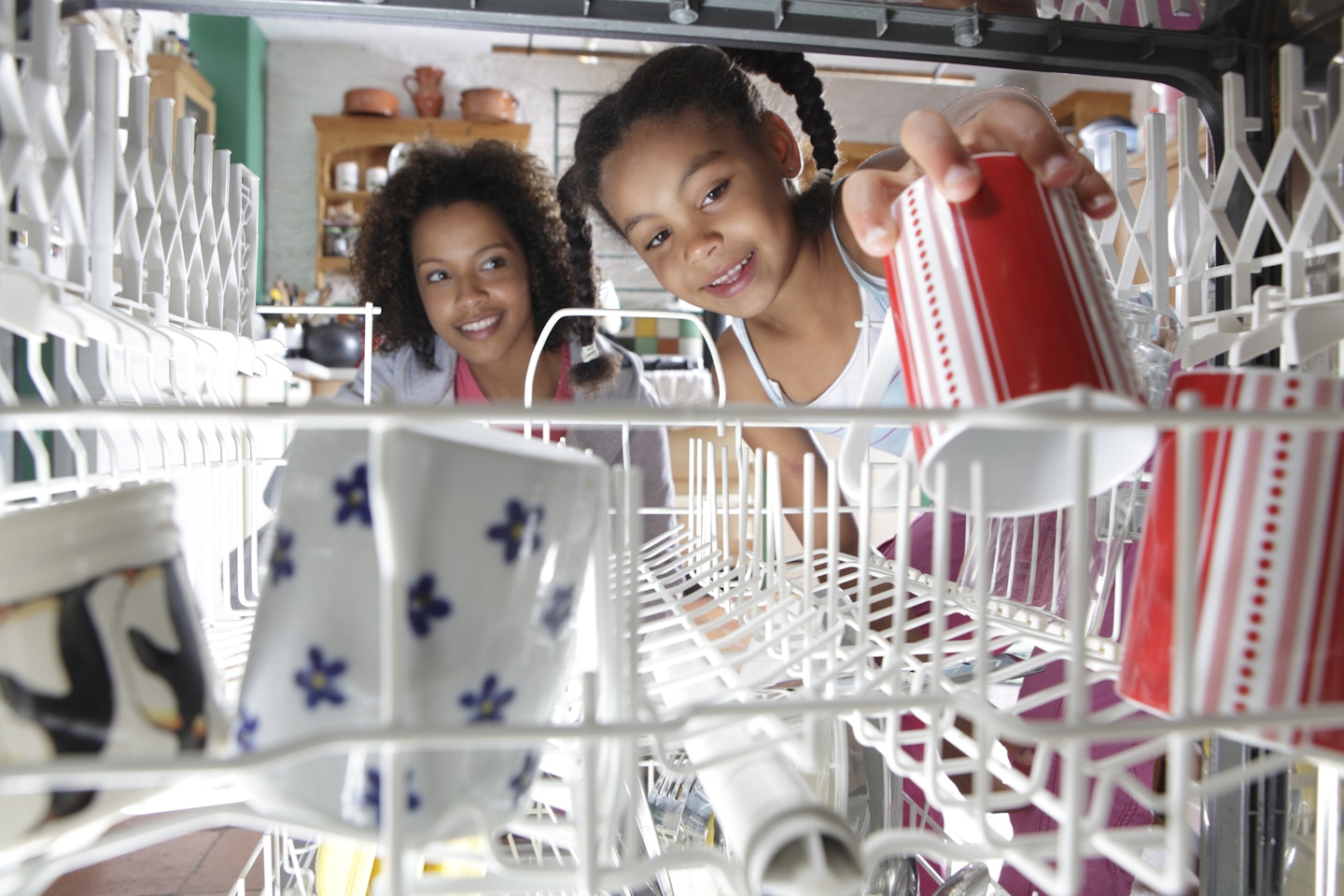 mother and daughter loading dishwasher
