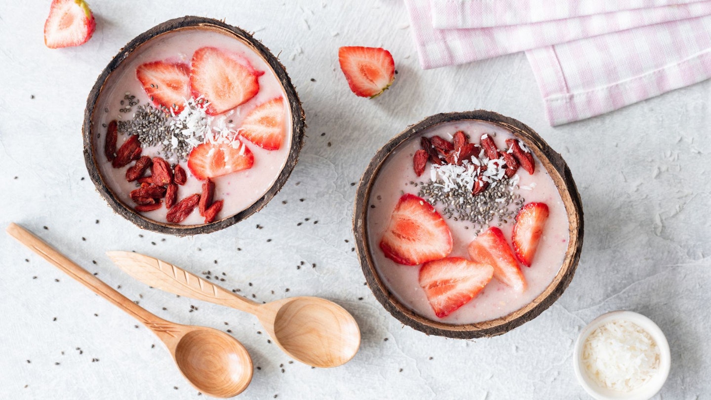Strawberry smoothie bowl topped with superfoods. Table top view