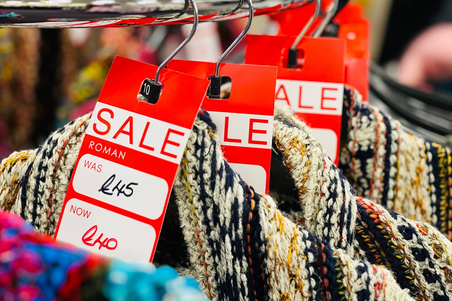 Clothes hanging on a rail with Sale signs on them