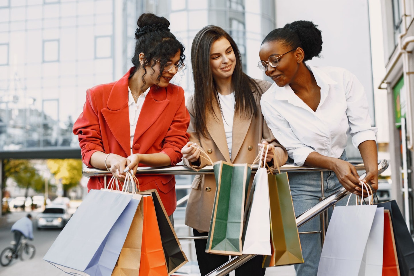 Three female friends comparing their shopping bags