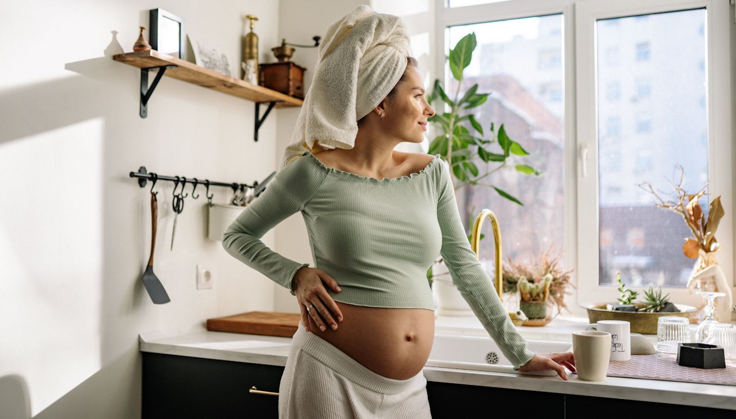 A Pregnant Woman Standing with Hand on her Belly