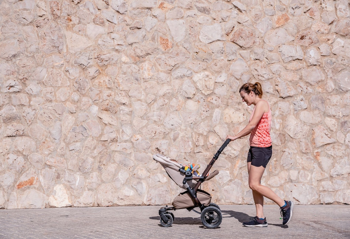 Young Mother Running with Baby Stroller