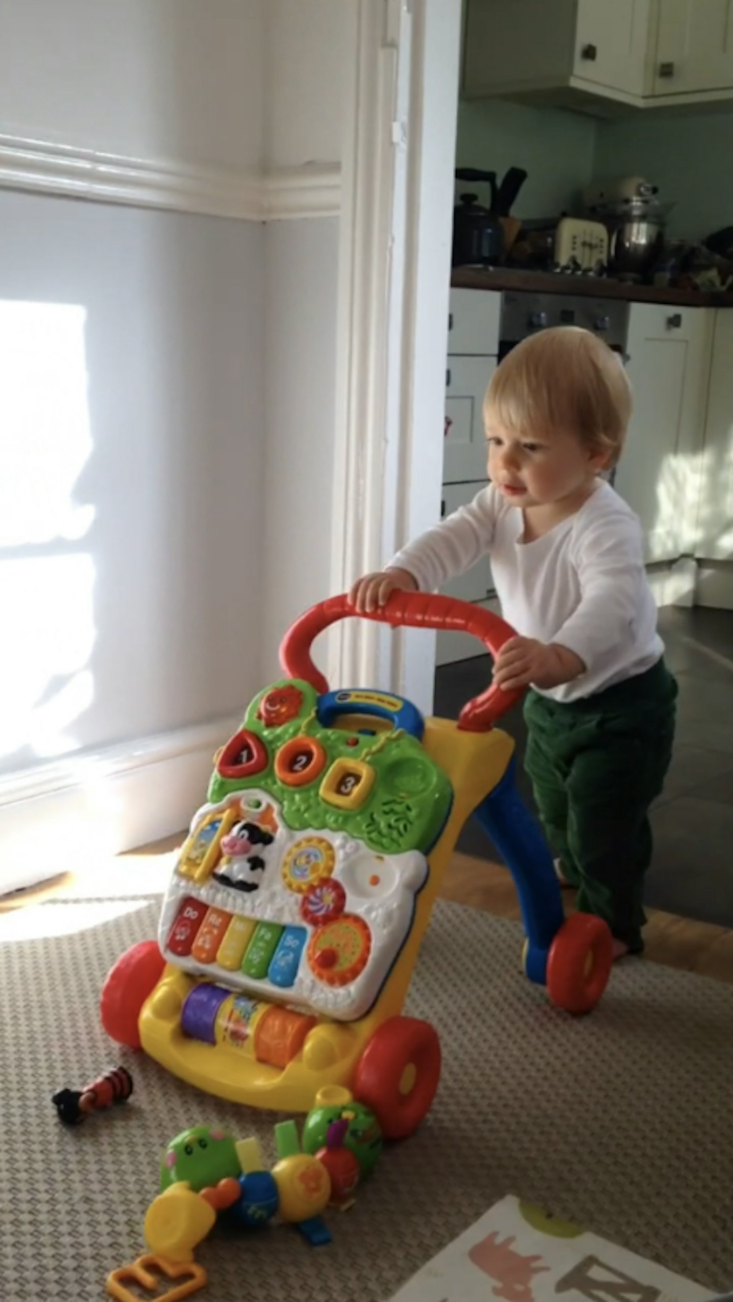 Image of a little boy playing with  the vtech walker in his house