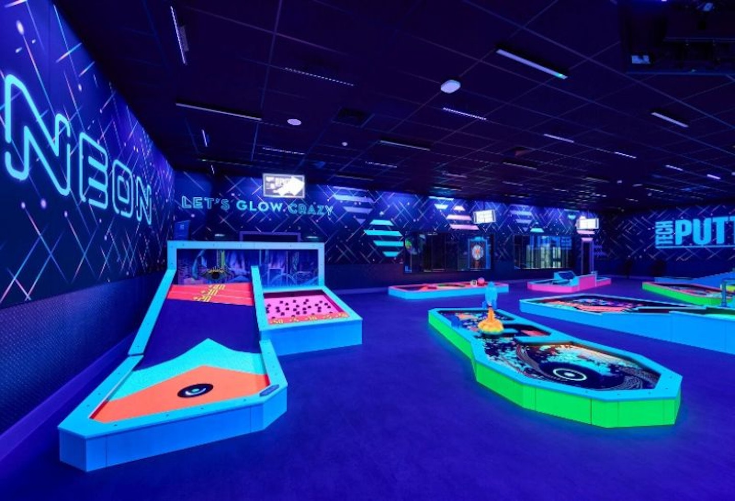 a neon room with crazy golf holes at Butlins Playxperience