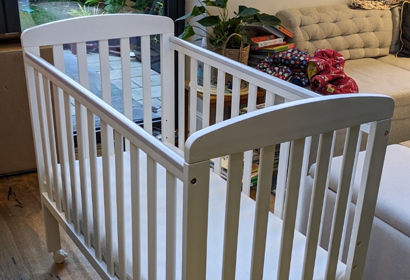 Babymore Space Saver cot with mattress in a bedroom