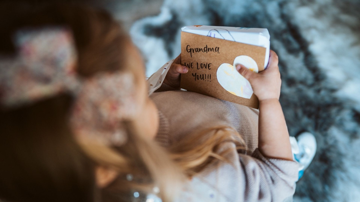 Girl holding Mothers Day gift for Grandma