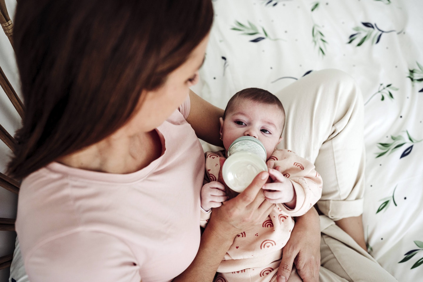 Mother feeding daughter milk through bottle