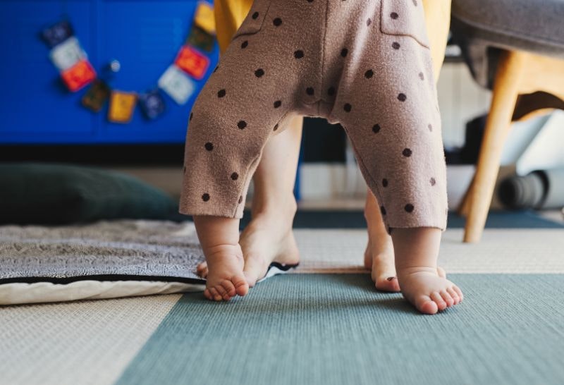 A toddler taking its first steps on different types of textured materials