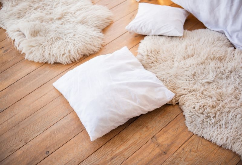 Cushions and sheepskin rugs on a floor as an obstacle course