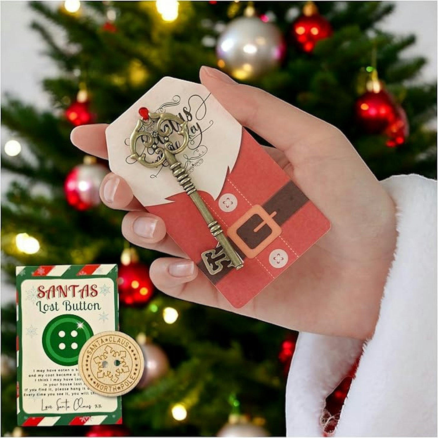 Hand holding Santa key next to Santa's lost button with a Christmas tree in the background