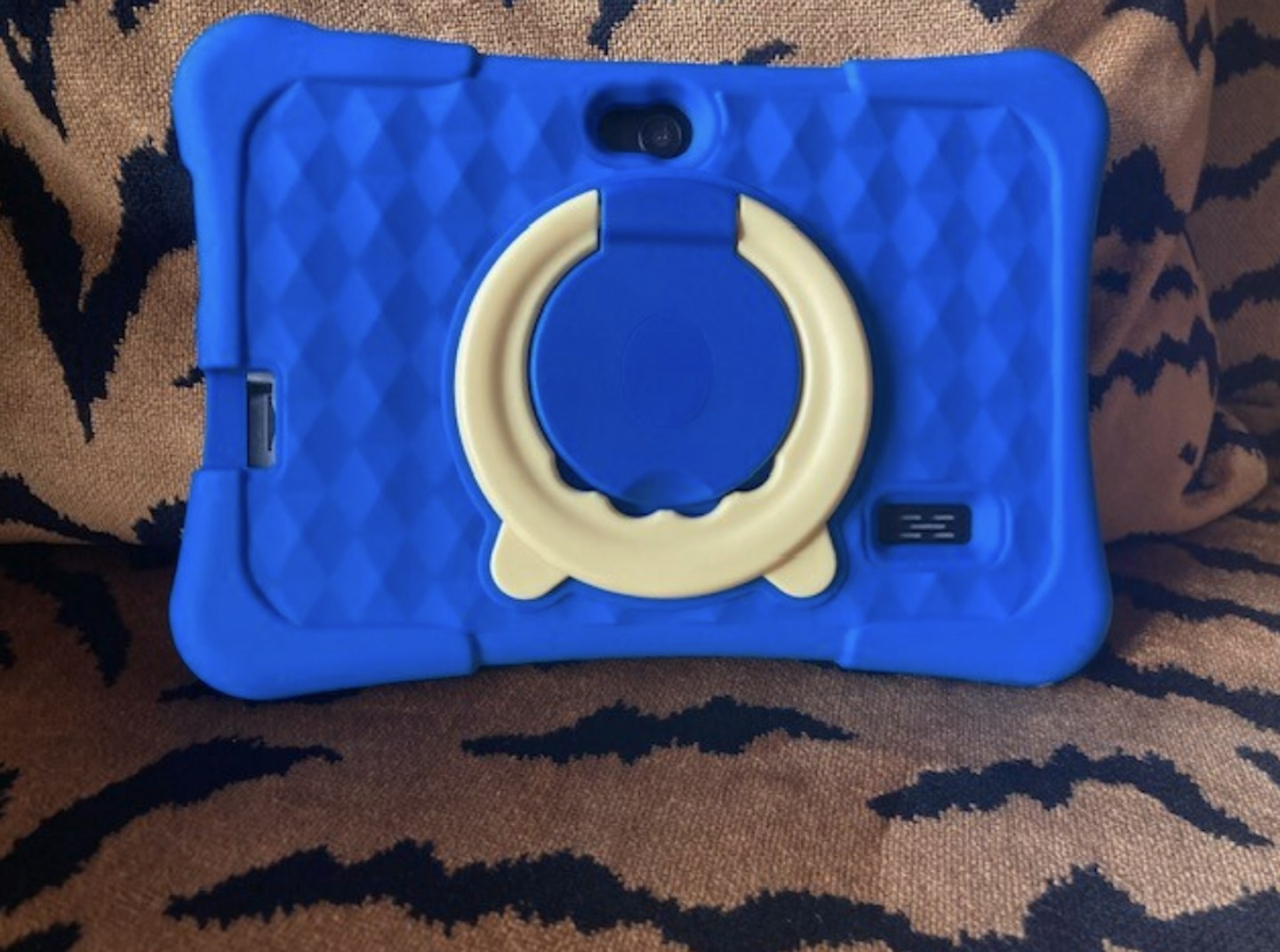 image of a blue pritom tablet sitting on an animal print sofa