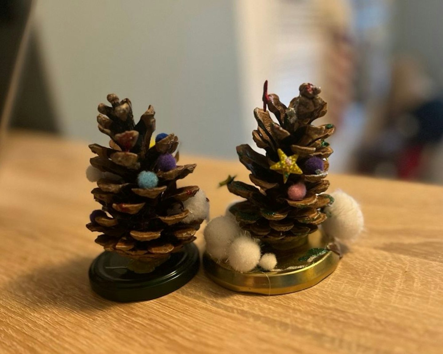 Two pinecones decorated as Christmas trees
