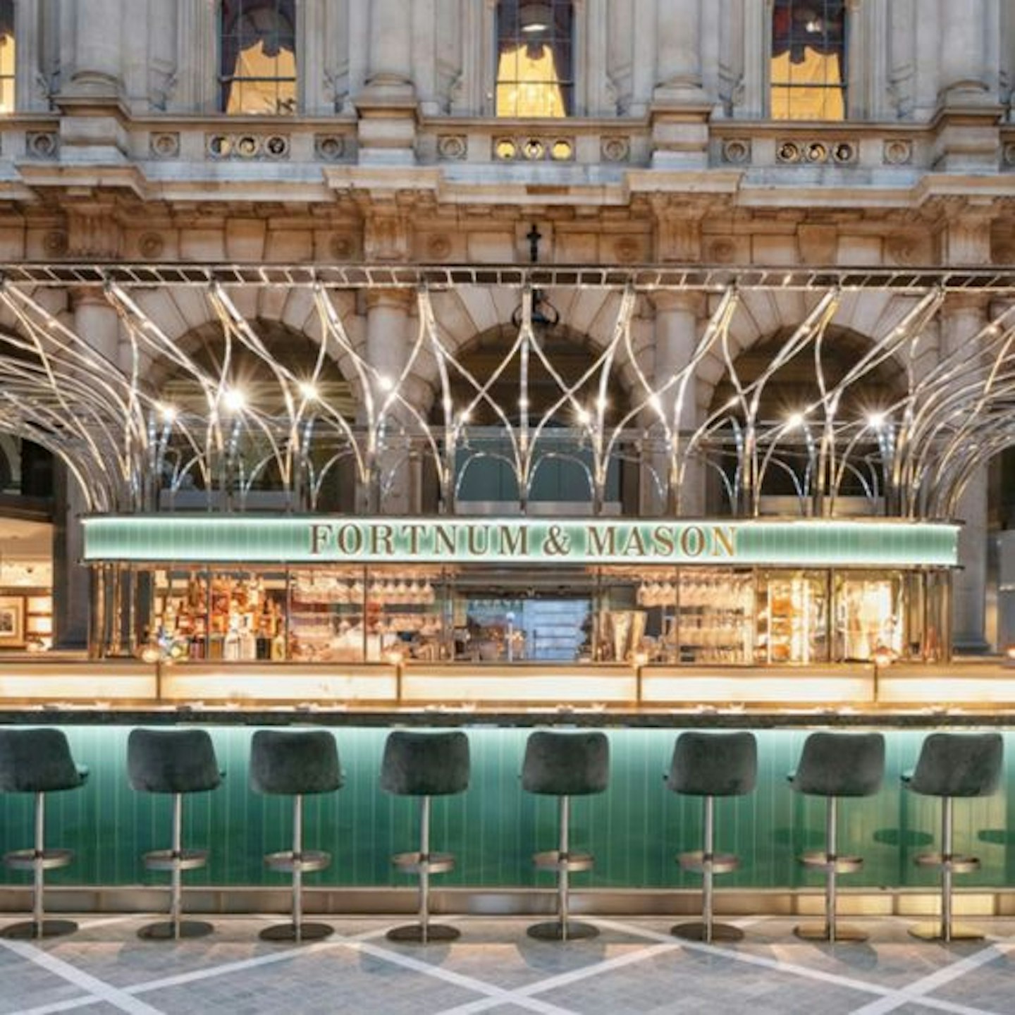 The bar at Fortnum and Mason with green chairs lined up