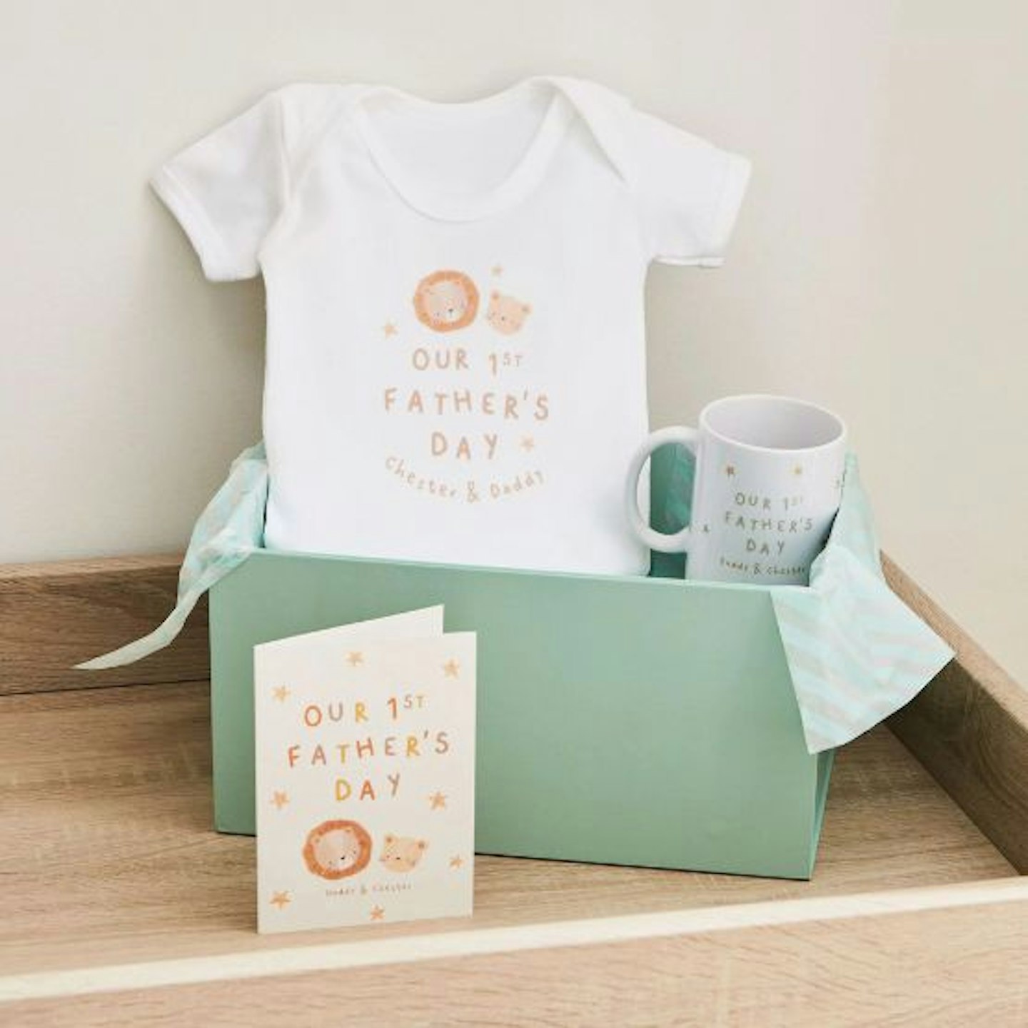 Personalised first fathers day gift box in green featuring a baby bro that says 'our first fathers day' and two names, a mug and a cup.