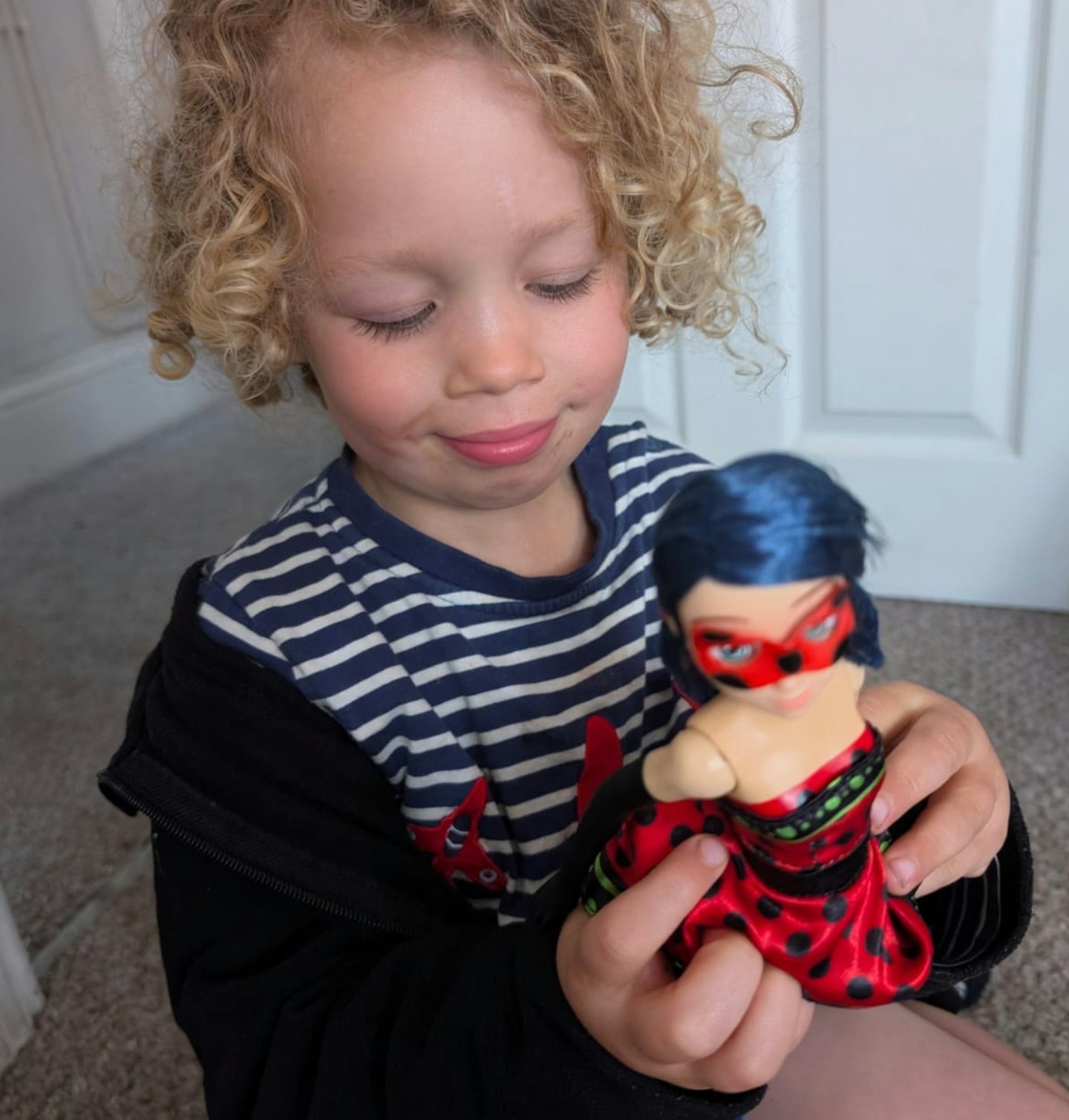 A little boy playing with Bandai Miraculous Hero Switch Ladybug Doll