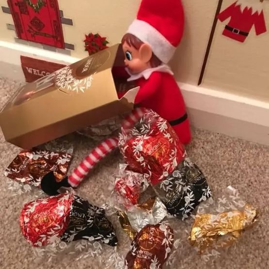 An elf surrounded by empty sweet wrappers