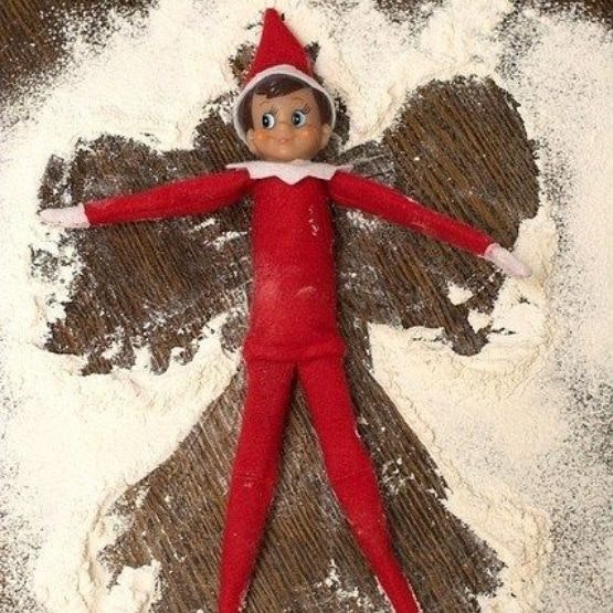An elf making a snow angel in flour