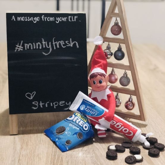 an elf replacing the cream in oreo cookies with toothpaste and a sign saying #mintyfresh